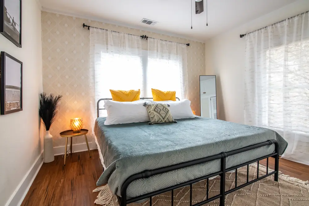 Unit A bedroom with yellow pillows and sheer curtains