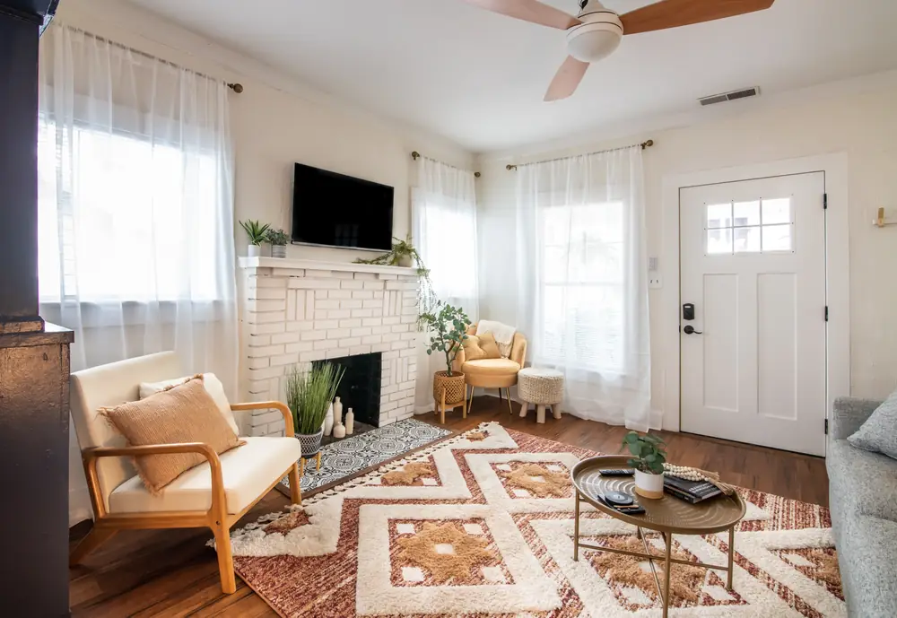 Unit A white brick fireplace with armchairs
