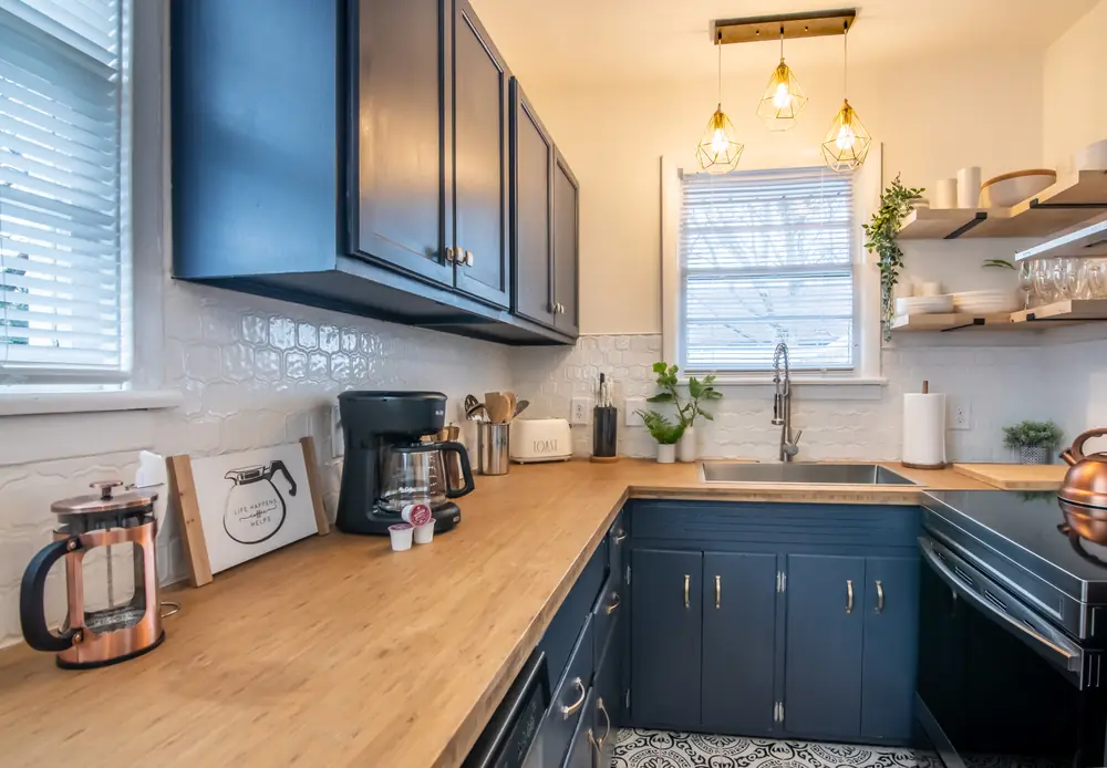Unit A kitchen with navy cabinets and butcher-block counters